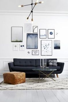 a living room with pictures on the wall and a couch next to a table in front of it