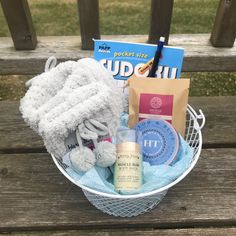 a basket filled with personal care items on top of a wooden bench next to a book