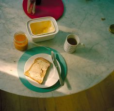 there is a plate with bread and orange juice on it