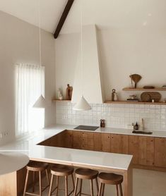 a kitchen with white counter tops and wooden stools