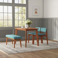 a dining table with two chairs and a bench in front of a window on a rug