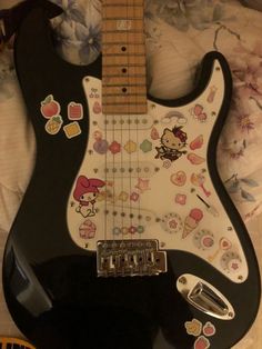 an electric guitar with hello kitty stickers on it