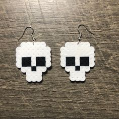 a pair of white and black pixelated sheep earrings