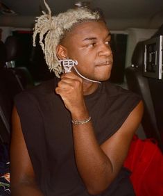 a man with dreadlocks on his head sitting in the back seat of a car