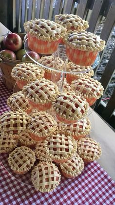 a table topped with lots of pies and cupcakes on top of a checkered table cloth