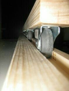 a close up view of a wooden bench with metal latches on it's sides