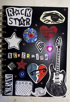 an open notebook with stickers and magnets on the cover that says rock star