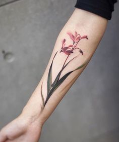 a person's arm with a flower tattoo on it