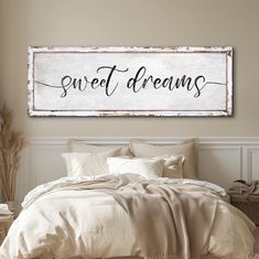 a bed sitting under a wooden sign that says sweet dreams