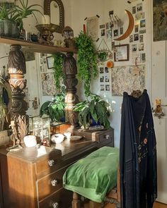 a room filled with lots of plants and pictures on the wall above a dresser next to a bed