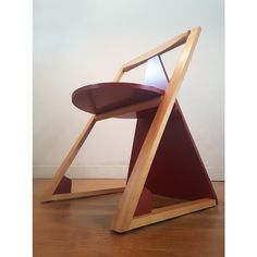 a wooden chair sitting on top of a hard wood floor next to a white wall