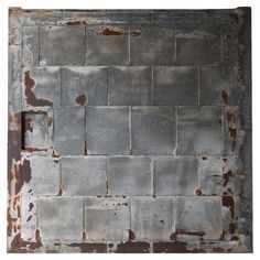 an old metal plate with rusted paint on the edges and square holes in it