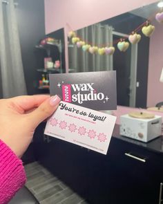 a person holding up a business card in front of a mirror