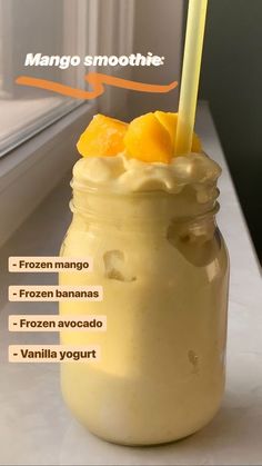 a glass jar filled with ice cream and orange slices on top of a counter next to a window