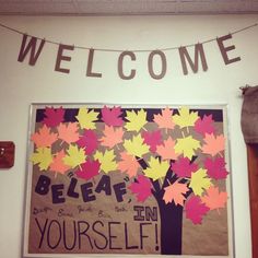 a welcome sign hangs on the wall next to a bulletin board with leaves and words