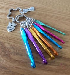 a bunch of different colored toothbrushes sitting on top of a wooden table next to a keychain