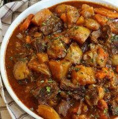 a white bowl filled with stew on top of a table