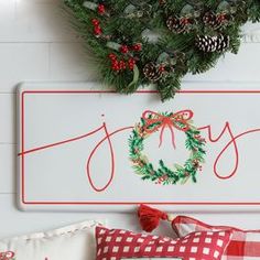 a christmas wreath is hanging on the wall above a bed with pillows and throw pillows