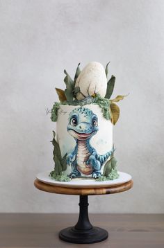 a cake decorated with an image of a baby dragon on top of a wooden table