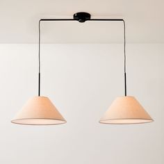 two lamps hanging from the ceiling in a room with white walls and flooring,