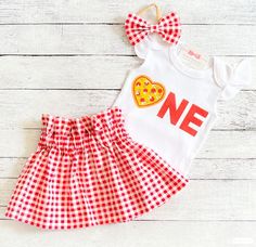 a white shirt and red checkered skirt with a pizza on the front that says one