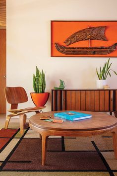 a living room filled with furniture and a painting on the wall above it's coffee table