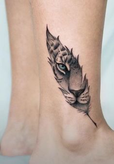 a tiger's head with a feather tattoo on its leg, and an eye in the center