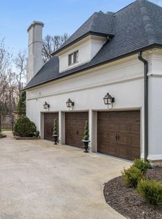 a large white house with two brown garage doors