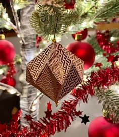 an ornament hanging from a christmas tree with red and gold ornaments on it