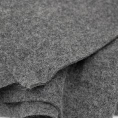 a close up view of the side of a gray wool material with folds and edges