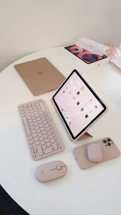 an apple computer, keyboard, mouse and tablet on a white table with other accessories