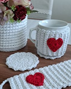 crocheted coffee mug cozys with red heart on the inside and white cup holder