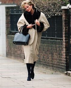 a woman walking down the street carrying a handbag