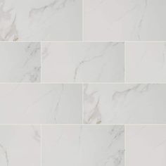 white marble tiles are arranged in rows and diagonals to create a unique pattern on the wall