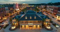 an aerial view of the town square at night with lights on and buildings lit up