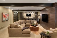 a living room filled with lots of furniture and a flat screen tv mounted to the wall