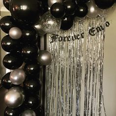 black and silver balloons are hanging on the wall