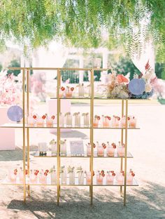 a table with lots of bottles on it and flowers in vases next to it