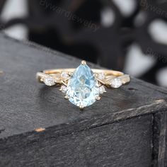 a ring with an aqua blue topazte surrounded by white and yellow diamond accents