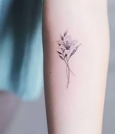 a small flower tattoo on the arm