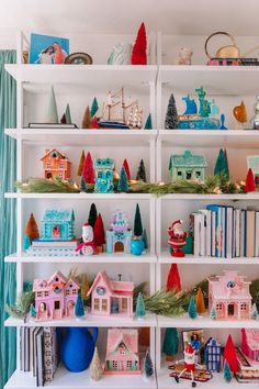 a shelf filled with lots of different types of toy houses and toys on top of it