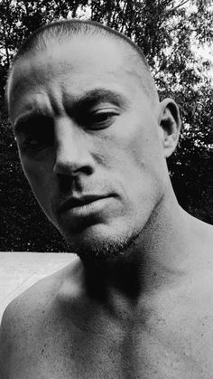 black and white photograph of a man with no shirt on looking off to the side