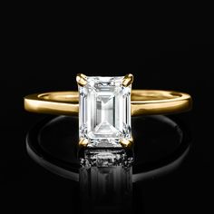 an emerald - cut diamond sits on a black surface