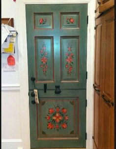 a green door with red flowers painted on it