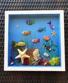 an ocean scene with fish and starfish on the bottom is framed in a white frame