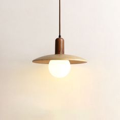 a wooden light hanging from a ceiling in a room with white walls and flooring