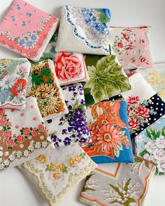 a pile of different colored handkerchiefs sitting on top of a white table next to each other