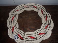 a white rope with red and black stripes on it sitting on top of a wooden table