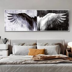 an image of two white and black angel wings on a wall above a large bed