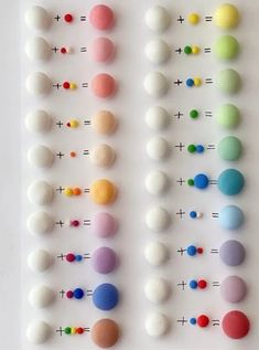 an array of different colored balls on a white surface with numbers and dots in the middle